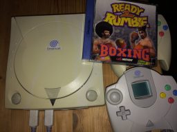 Im Bild ist die Sega Dreamcast meines Bruders zu sehen. Das Spiel Ready 2 Rumble hatte ihn „angefixt“. Ja genau so hat er sich ausgedrückt. Die Konsole musste er unbedingt haben und wurde deshalb sofort spontan gekauft. Kein Fehlkauf wie ich finde. (Bild: Ferdinand Müller)